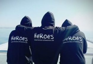 Drei HEROES mit ihren HEROES-Sweatshirts von hinten.